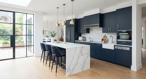 Navy cabinetry kitchen with marble waterfall island